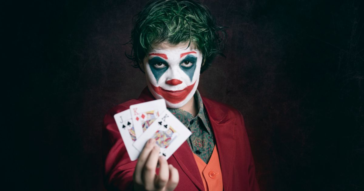 Man dressed as joker with playing cards